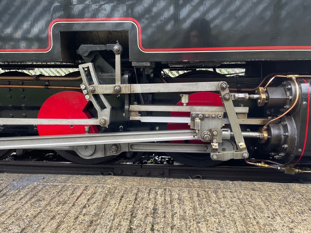 A side view of the black engine, including parts of the wheels and piston arrangement. The wheel parts are picked out in silver and red. So many exciting and graceful parts!